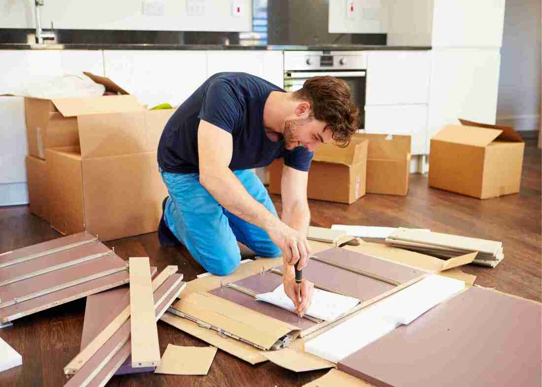 Young Man assembling furniture out of a box