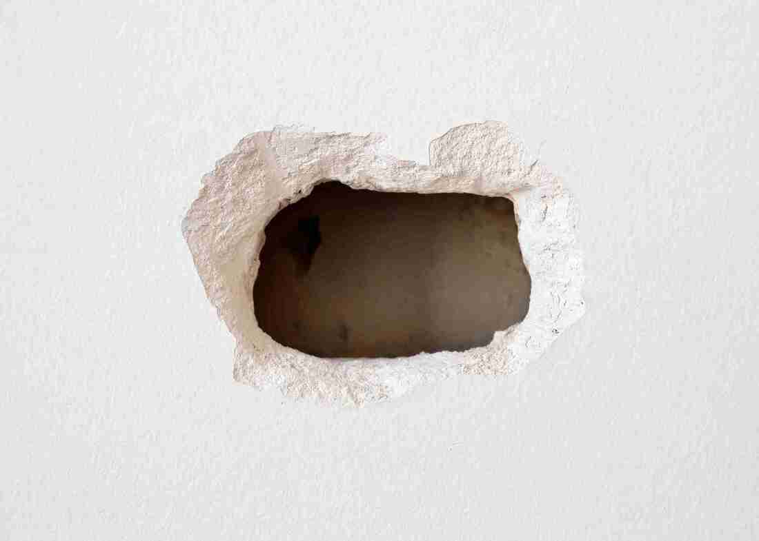 A hole in a plaster wall to be repaired