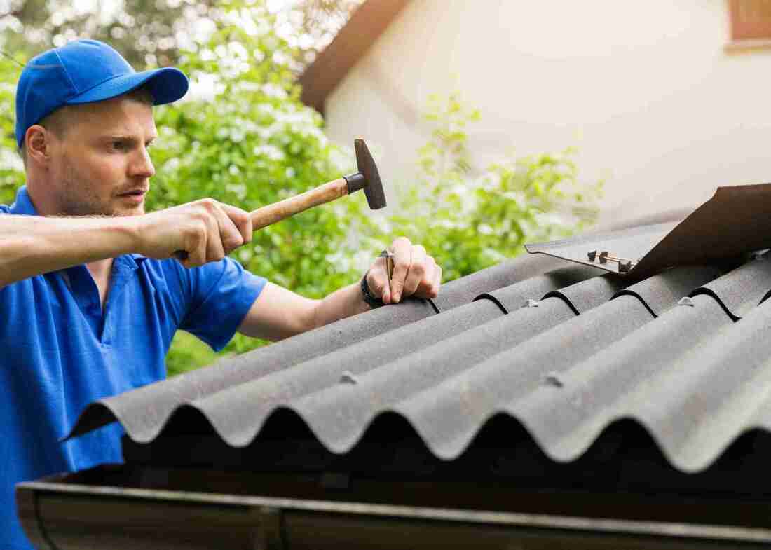 Tradie installing Bitumen Roof Sheets